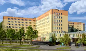 Szpital Wojewódzki Specjalistyczny w Olsztynie z niebieskim niebem i chmurami.