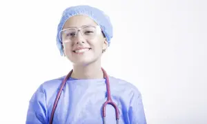 Uśmiechnięta lekarka w czepku i okularach, z różowym stetoskopem. Szukasz najlepszych klinik medycyny estetycznej we Wrocławiu?
