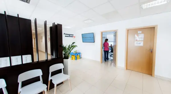 Najlepsze kliniki leczenia niepłodności w Krakowie - ranking placówek. Poczekalnia z wygodnymi fotelami i tablicą informacyjną.