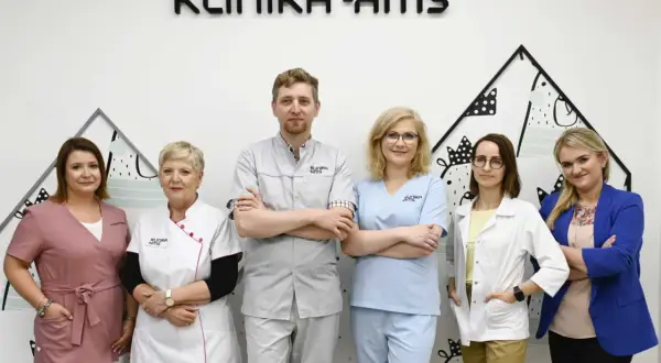 Zespół medyczny w klinice, sześć osób w uniformach medycznych, na tle logo kliniki.