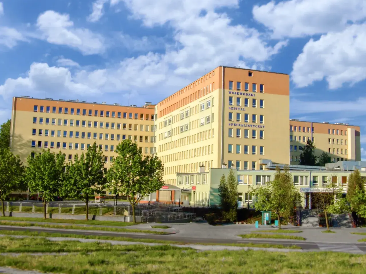 Szpital Wojewódzki Specjalistyczny w Olsztynie z niebieskim niebem i chmurami.