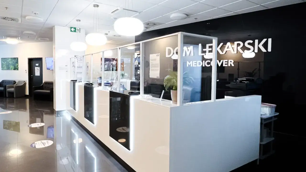 Nowoczesna recepcja kliniki Medicover w Szczecinie z białym ladą i szklanymi przegrodami.