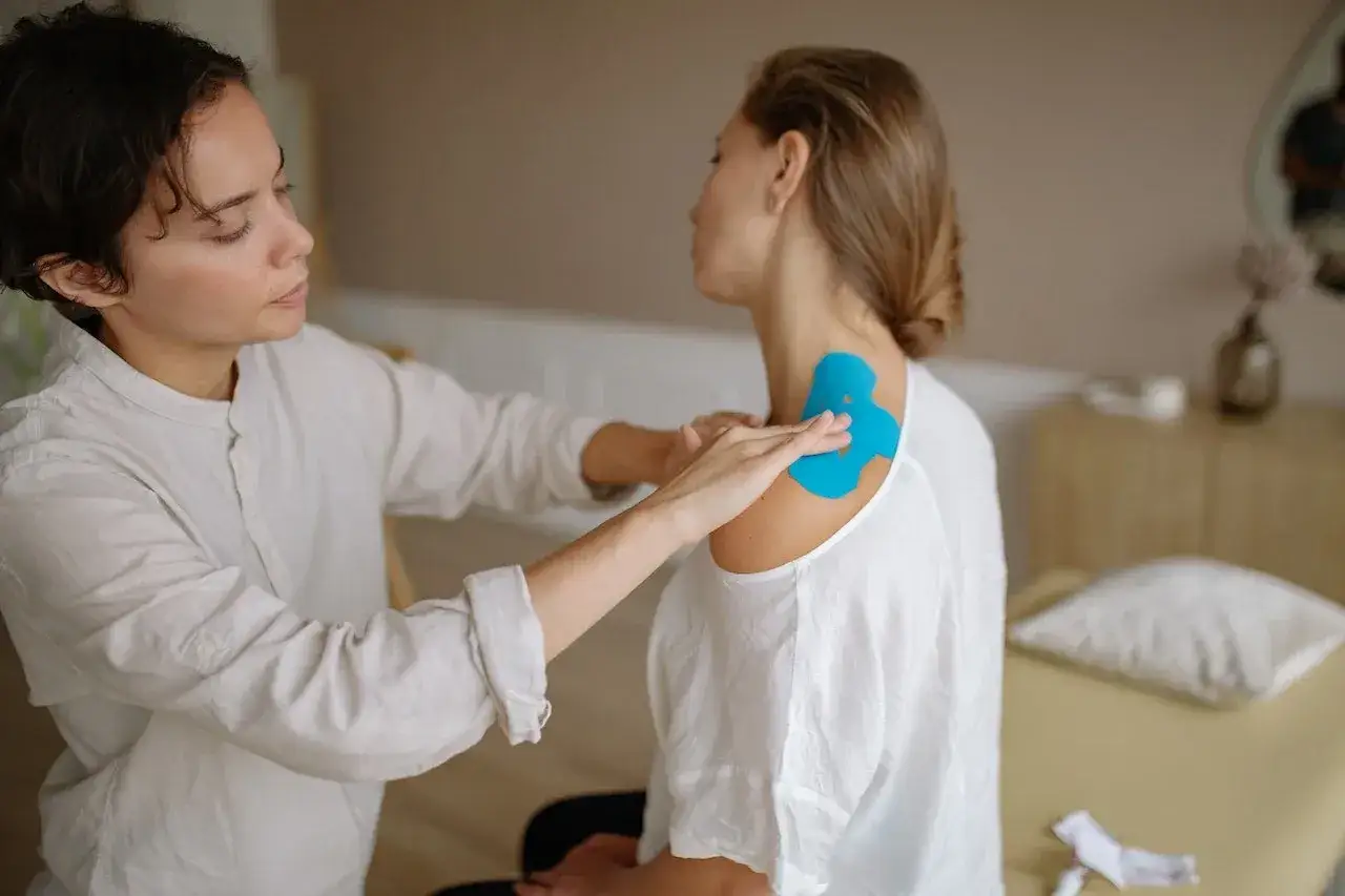Pacjent wykonujący ćwiczenia rehabilitacyjne pod okiem fizjoterapeuty
