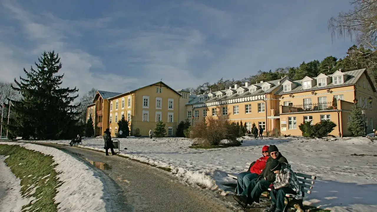 Porównanie sanatorium NFZ i prywatnego, dwa budynki lub infografika