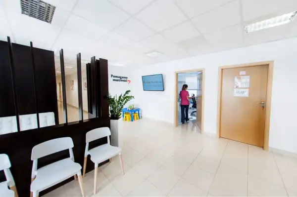 Najlepsze kliniki leczenia niepłodności w Krakowie - ranking placówek. Poczekalnia z wygodnymi fotelami i tablicą informacyjną.