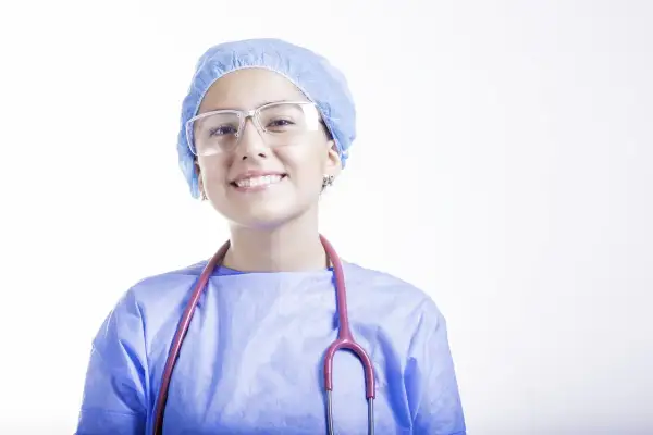 Uśmiechnięta lekarka w czepku i okularach, z różowym stetoskopem. Szukasz najlepszych klinik medycyny estetycznej we Wrocławiu?